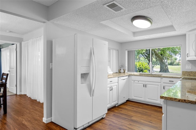 kitchen with stone counters, dark wood-type flooring, white appliances, and white cabinets