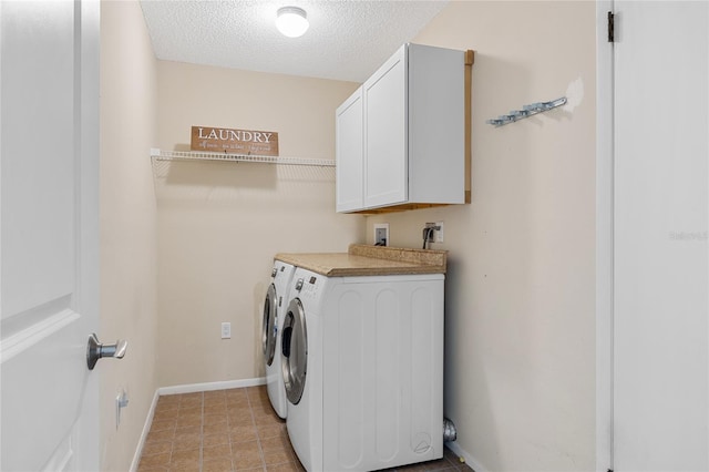 laundry room featuring light tile patterned floors, independent washer and dryer, a textured ceiling, and cabinets