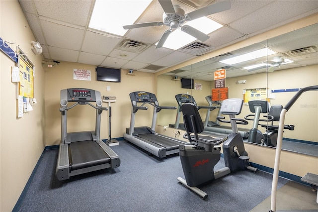 gym featuring ceiling fan, carpet, and a paneled ceiling