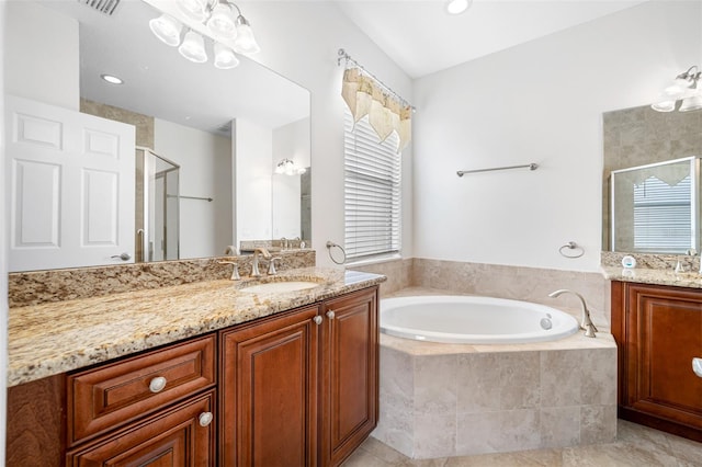 bathroom with a stall shower, two vanities, a sink, and a bath