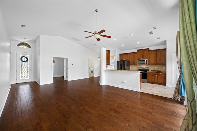 1008 Blue Heron Way, Tarpon Springs, FL 34689 - unfurnished living room with ceiling fan, light wood finished floors, high vaulted ceiling, washer / clothes dryer, and baseboards