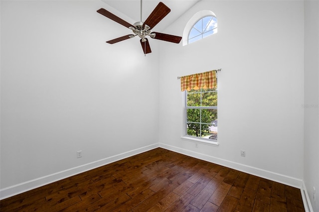1008 Blue Heron Way, Tarpon Springs, FL 34689 - empty room with dark wood-style floors, plenty of natural light, baseboards, ceiling fan, and high vaulted ceiling