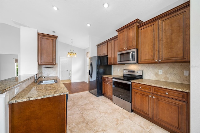 kitchen with a peninsula, brown cabinets, a sink, and stainless steel appliances