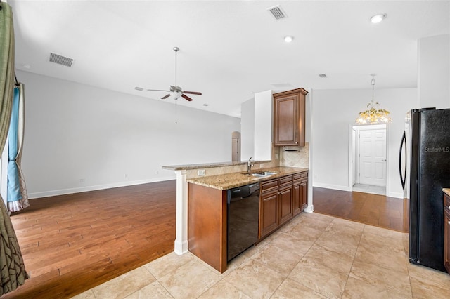 kitchen with black appliances, a peninsula, and visible vents