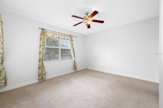 spare room featuring carpet floors, ceiling fan, and baseboards