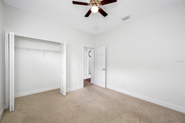 unfurnished bedroom with a closet, visible vents, light carpet, and baseboards