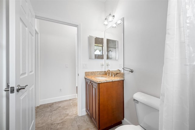 bathroom featuring baseboards, vanity, and toilet