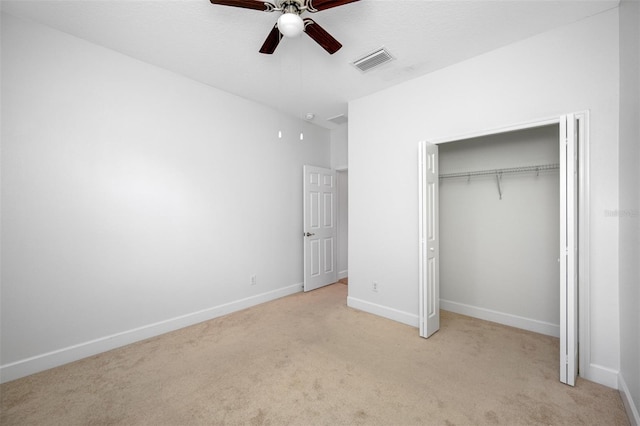 unfurnished bedroom featuring baseboards, visible vents, a ceiling fan, light colored carpet, and a closet