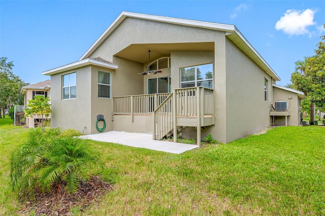 back of house with a yard and stucco siding