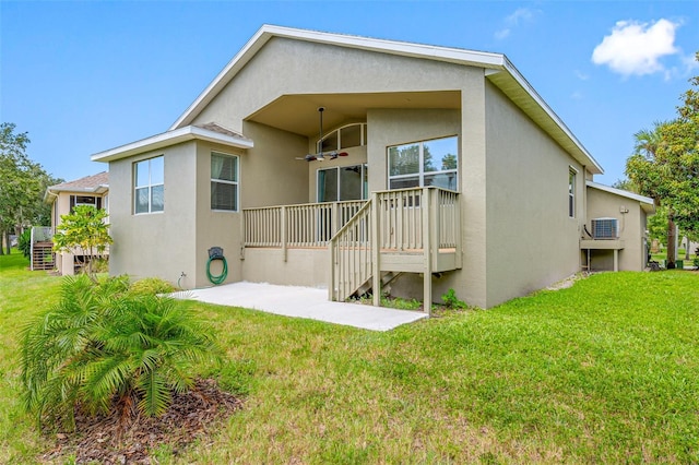 1008 Blue Heron Way, Tarpon Springs, FL 34689 - rear view of house featuring a yard, stucco siding, and stairway