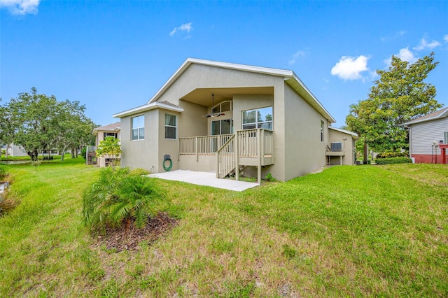 rear view of house with a yard and stucco siding