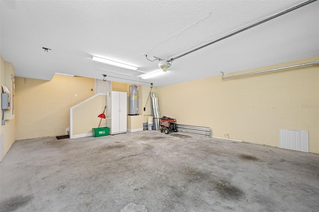 garage with a garage door opener, concrete block wall, electric water heater, and visible vents