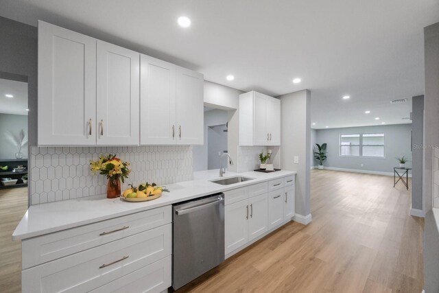 kitchen featuring a sink, light wood-style flooring, white cabinetry, and dishwasher