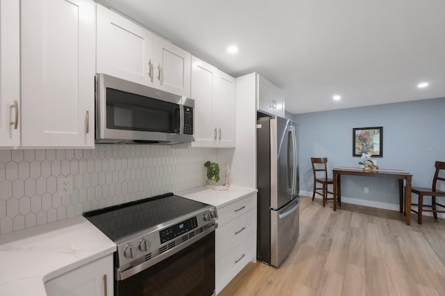 kitchen featuring white cabinetry, appliances with stainless steel finishes, light wood-style flooring, and recessed lighting