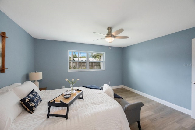 bedroom featuring ceiling fan, baseboards, and wood finished floors