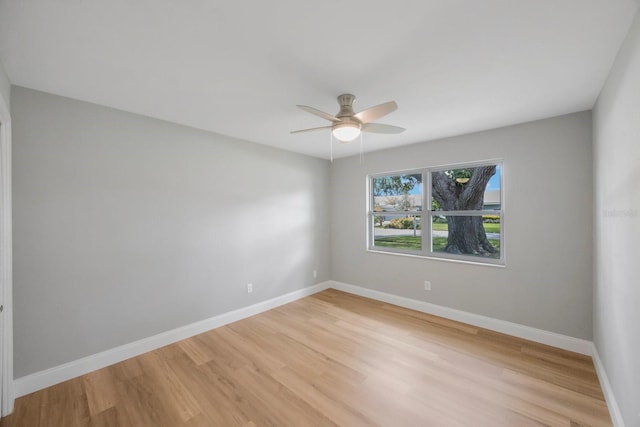 unfurnished room with a ceiling fan, light wood-style flooring, and baseboards