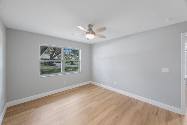 unfurnished room featuring a ceiling fan, light wood-style flooring, and baseboards