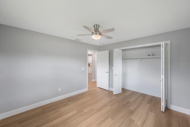 unfurnished bedroom featuring a ceiling fan, baseboards, visible vents, light wood-style floors, and a closet