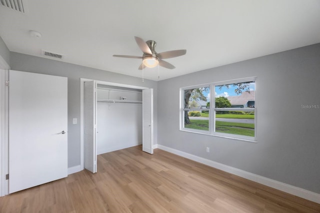 unfurnished bedroom with baseboards, a closet, visible vents, and light wood-style floors