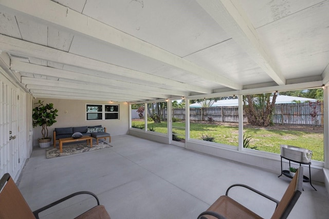 unfurnished sunroom with beam ceiling