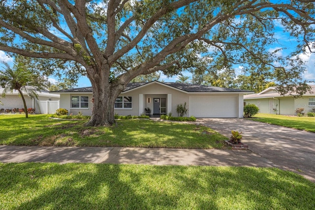 ranch-style house featuring a front yard, an attached garage, and stucco siding