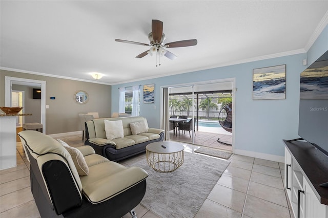 living room with light tile patterned floors, baseboards, ceiling fan, and crown molding