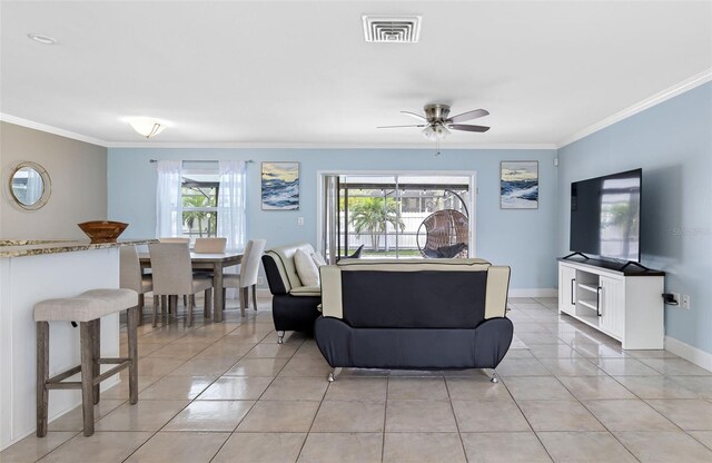 tiled living room featuring ceiling fan, crown molding, and a healthy amount of sunlight