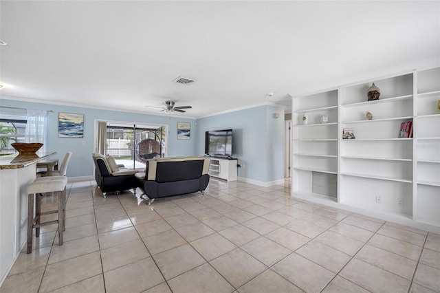 living area with built in shelves, crown molding, baseboards, ceiling fan, and light tile patterned flooring