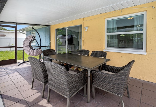 view of patio with glass enclosure and outdoor dining area