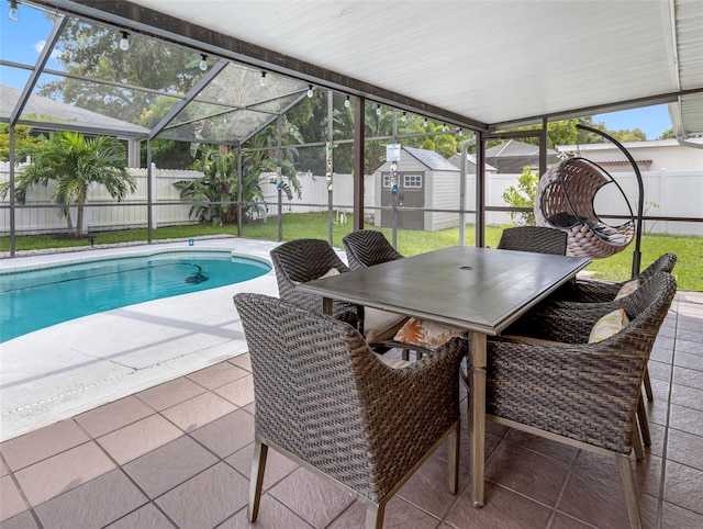 view of swimming pool with glass enclosure, a shed, and a patio