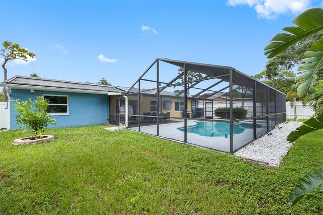 back of property with a patio area, a fenced in pool, a lawn, and a lanai