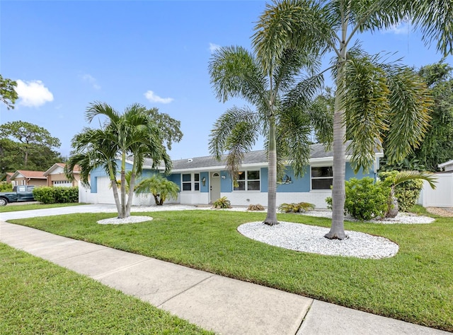 ranch-style house with an attached garage, concrete driveway, and a front yard