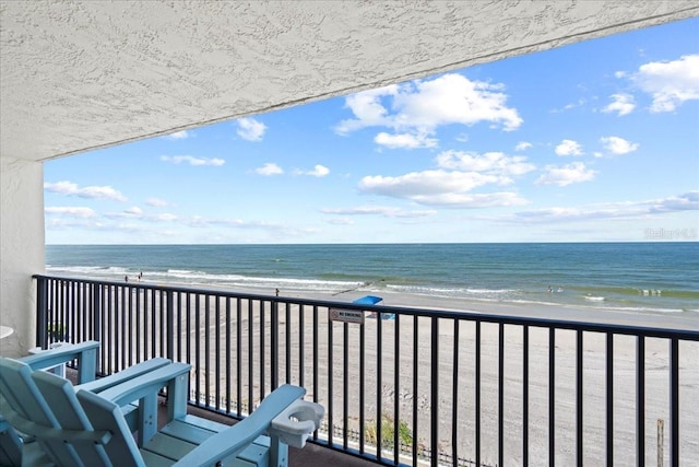 balcony with a beach view and a water view