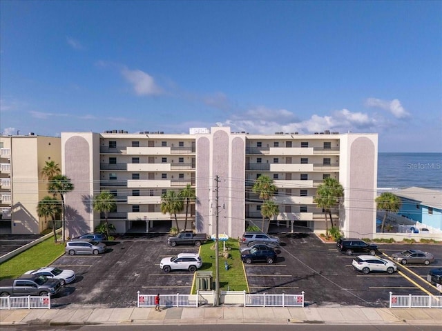 view of property featuring uncovered parking and a water view