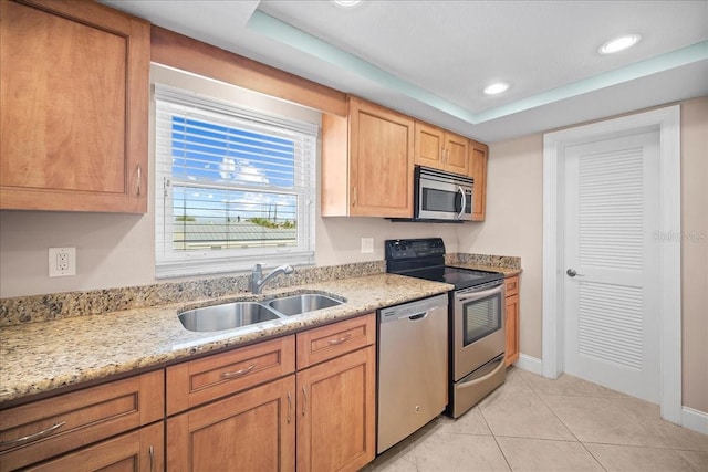 kitchen with light tile patterned floors, a raised ceiling, stainless steel appliances, a sink, and recessed lighting