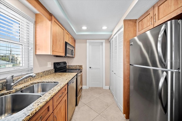 kitchen with light tile patterned flooring, recessed lighting, a sink, baseboards, and appliances with stainless steel finishes