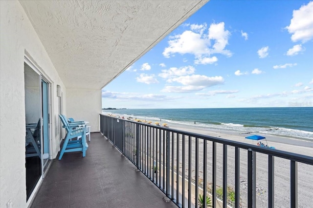 balcony with a water view and a beach view