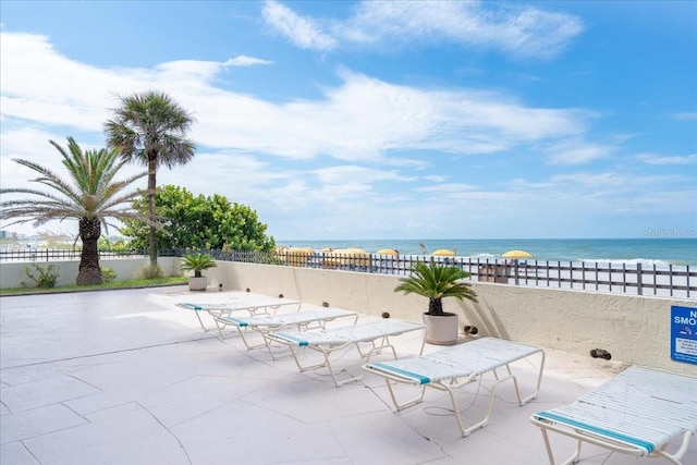 view of patio / terrace with a water view and fence