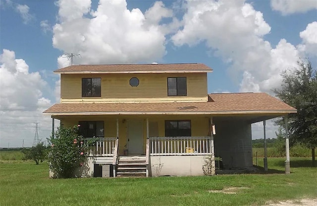 rear view of property featuring a yard and covered porch