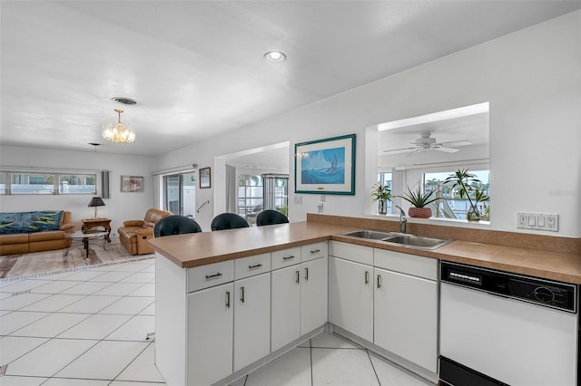 kitchen featuring white dishwasher, plenty of natural light, kitchen peninsula, and ceiling fan with notable chandelier