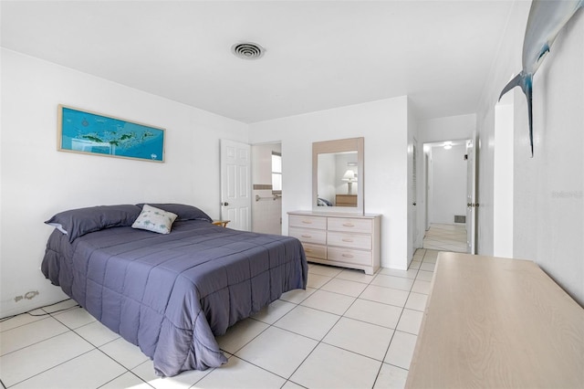 bedroom with connected bathroom and light tile patterned floors