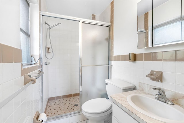 bathroom with tile walls, toilet, vanity, and backsplash