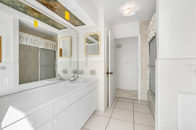 bathroom with tile walls, tile patterned flooring, walk in shower, and vanity