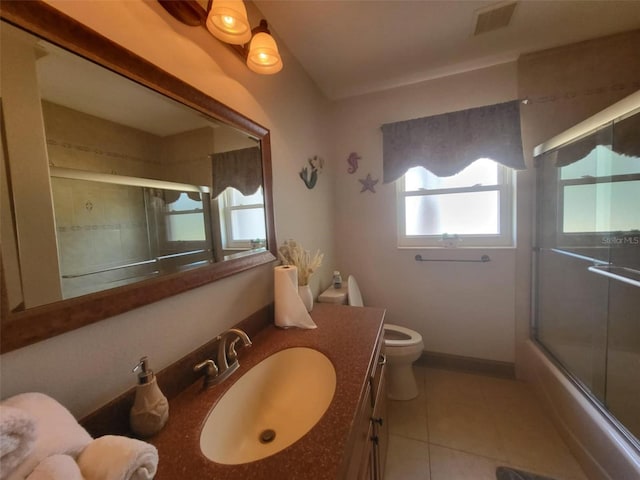 full bathroom featuring combined bath / shower with glass door, tile patterned flooring, vanity, and toilet