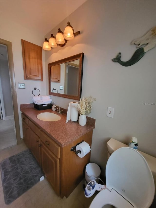 bathroom with tile patterned flooring, vanity, and toilet