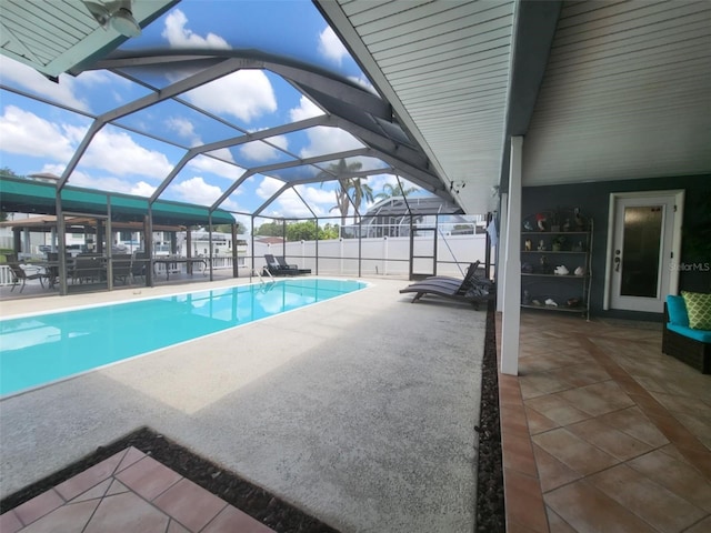 view of swimming pool featuring a patio area and a lanai