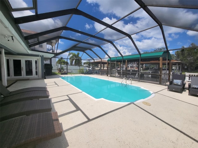 view of swimming pool featuring a patio and glass enclosure