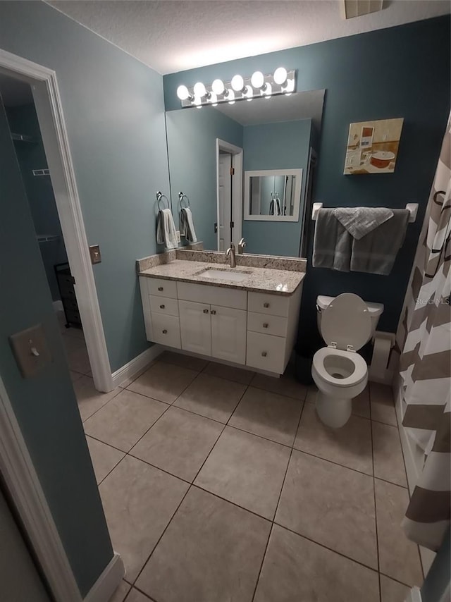 bathroom featuring tile patterned flooring, vanity, toilet, and a textured ceiling