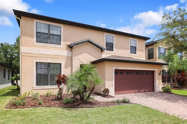 15250 Anguilla Isle Ave, Tampa, FL 33647 - view of front of property with an attached garage, a front yard, decorative driveway, and stucco siding