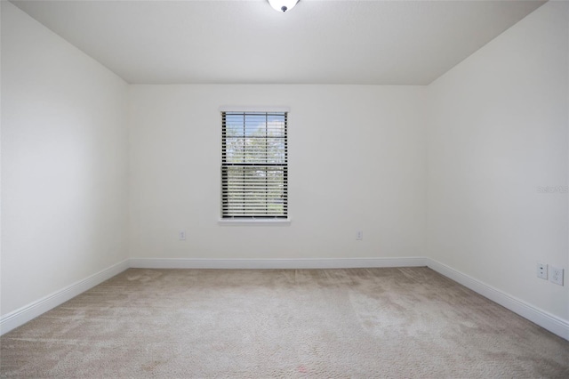 unfurnished room featuring light colored carpet and baseboards